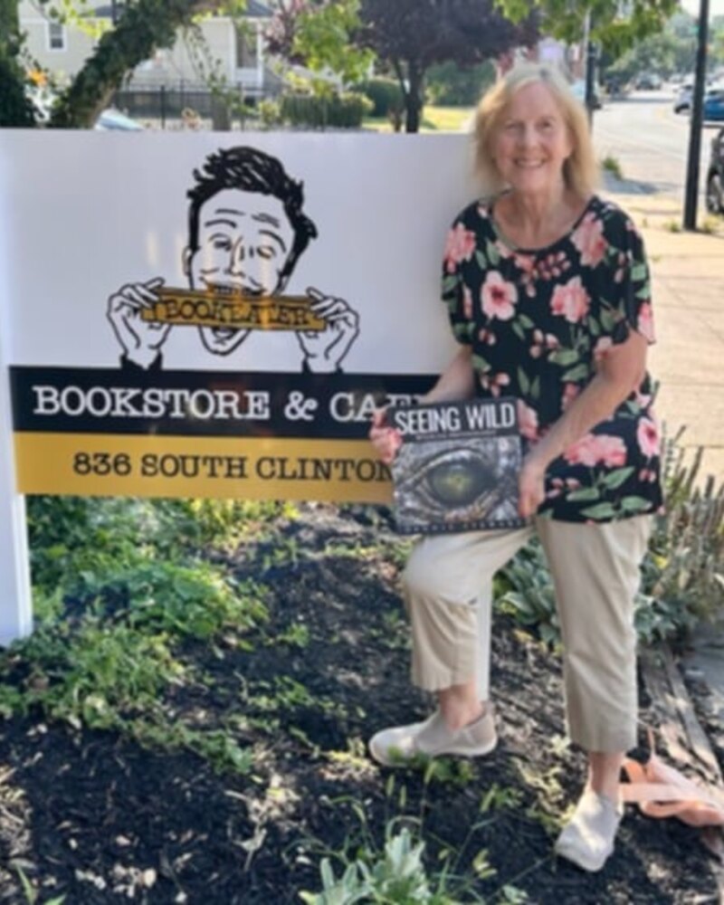 Reader holding Seeing Wild outside a bookstore