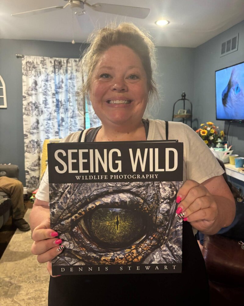 Smiling reader holding Seeing Wild
